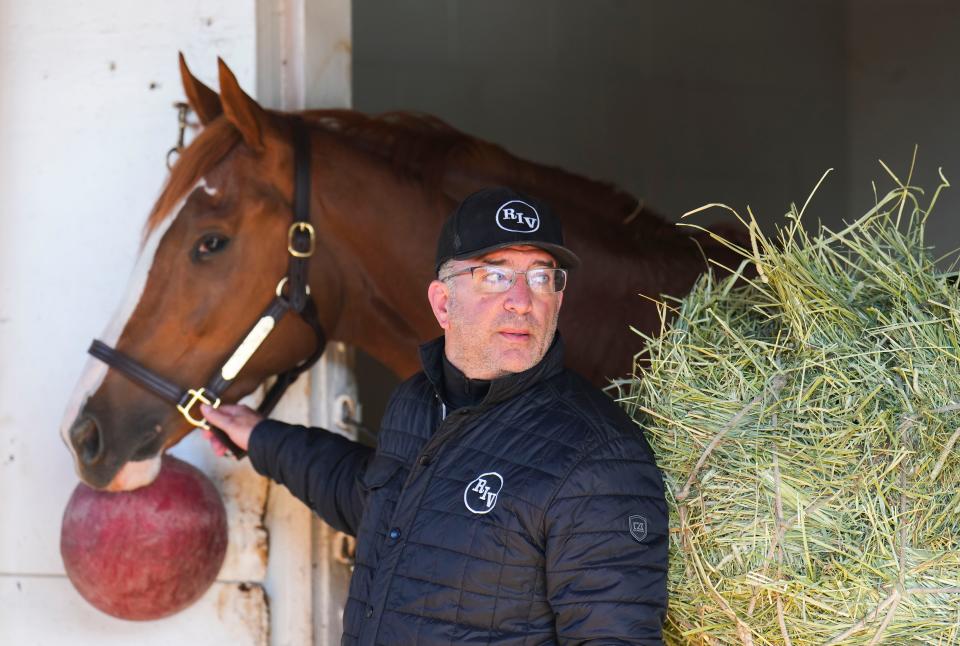 Kentucky Derby hopeful Two Phil's stands in his stall with trainer Larry Rivelli nearby after a workout Tuesday morning at Churchill Downs May 2, 2023, in Louisville, Ky.  