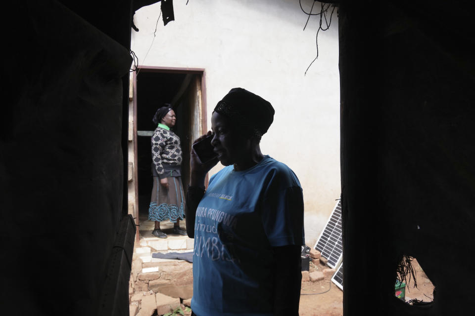 Siridzayi Dzukwa, a grandmother, talks on her mobile phone while on a home visit in Hatfcliffe on the outskirts of the capital Harare, Zimbabwe, Wednesday, May 15, 2024. In Zimbabwe, talk therapy involving park benches and a network of grandmothers has become a saving grace for people with mental health issues. Now the concept is being adopted in parts of the United States and elsewhere. (AP Photo/Tsvangirayi Mukwazhi)