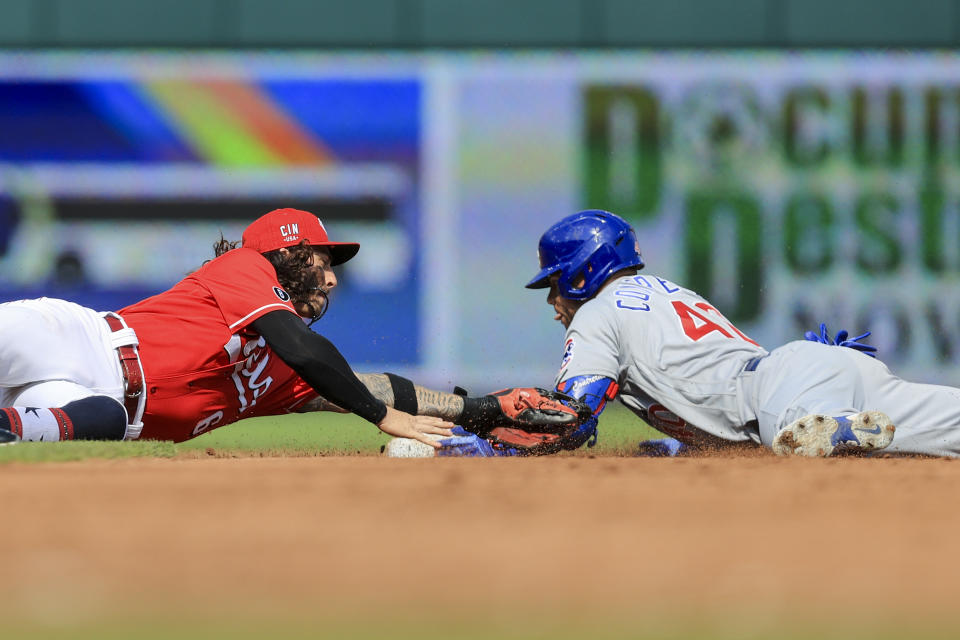 Chicago Cubs' Willson Contreras, right, slides safely into second base after hitting a double as he avoids a tag by Cincinnati Reds' Jonathan India, left, during the third inning of a baseball game in Cincinnati, Saturday, July 3, 2021. (AP Photo/Aaron Doster)