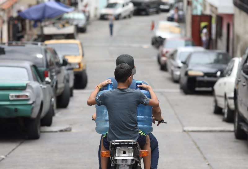 People carry plastic containers to refill water in the low-income neighbourhood of Artigas amid the coronavirus disease (COVID-19) outbreak in Caracas