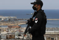 A Lebanese special forces policeman protecting UNESCO'S Director-General Audrey Azoulay, stands guards on the roof of a damaged school, that overlooks the site of the Aug. 4 explosion that hit the seaport, in Beirut, Lebanon, Thursday, Aug. 27, 2020. Azoulay is in Beirut for two days to mobilize the international community and make education, culture and heritage the main pillars of reconstruction efforts in the wake of the devastation. (AP Photo/Hussein Malla)