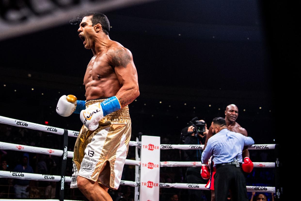 Brazilian martial artist Vitor Belfort (L) celebrates after knocking down US former professional boxer Evander Holyfield (R) during a boxing fight at Hard Rock Live in Hollywood, Florida on September 11, 2021. (Photo by CHANDAN KHANNA / AFP) (Photo by CHANDAN KHANNA/AFP via Getty Images)