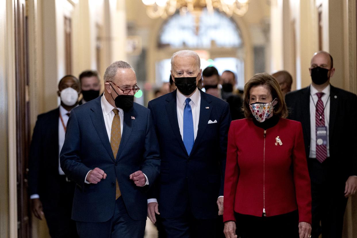 U.S. President Joe Biden, center, joined by Senate Majority Leader Chuck Schumer, (D-NY), left, and U.S. House Speaker Nancy Pelosi, (D-NY), walk through the Hall of Columns before speaking during a ceremony on the first anniversary of the deadly insurrection at the U.S. Capitol on Jan. 6, 2022, in Washington, DC.