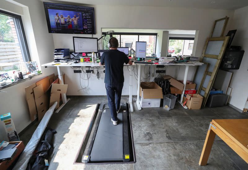 Belgian Yves Hanoulle, IT professional, walks on a treadmill as he works in his home in Ghent