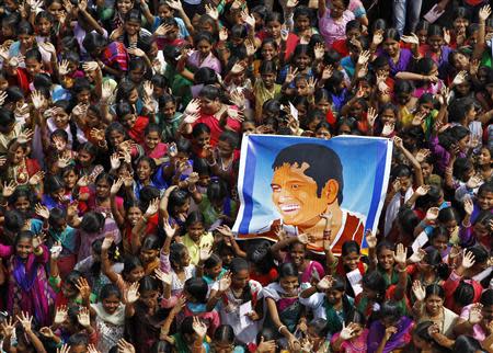 School children wave as they hold a poster of Indian cricketer Sachin Tendulkar at an event to honour him inside a school in the southern Indian city of Chennai November 14, 2013. Cricket-crazy India will have a lump in the throat as its favourite son, Tendulkar, walks out for one last time this week to play the game he has dominated for nearly a quarter of a century. The 'Little Master' will bring the curtain down on a glittering 24-year career at the age of 40 when he plays his 200th test match, against West Indies, at his home ground starting on Thursday. REUTERS/Babu