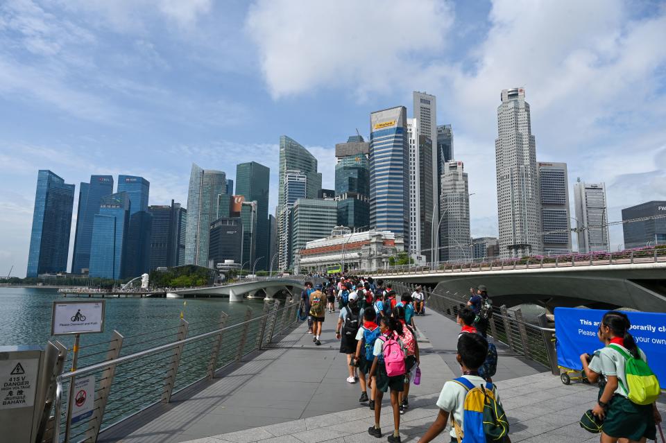 Teachers and students walk across the bridge at Marina Bay waterfront during an excursion in Singapore. 