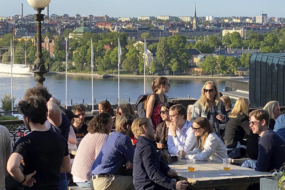 People enjoy drinks and snacks in the evening sun on a terrace overlooking Stockholm, on Tuesday, May 30, 2023. Smoking is prohibited in both indoor and outdoor areas of bars and restaurants in Sweden, which has the lowest share of smokers in the European Union. (AP Photo/Karl Ritter)