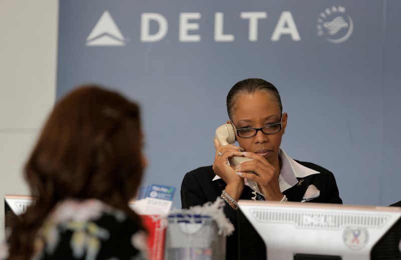 FILE PHOTO: A Delta Airlines ticketing agent assists a passenger after the airlines computer systems crashed leaving passengers stranded as flights were grounded globally at Ronald Reagan Washington National Airport in Washington.