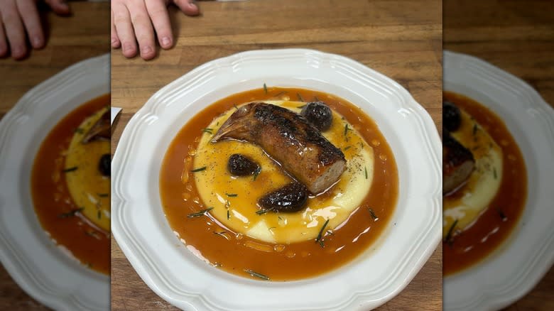 plated chicken neck sausage over potatoes