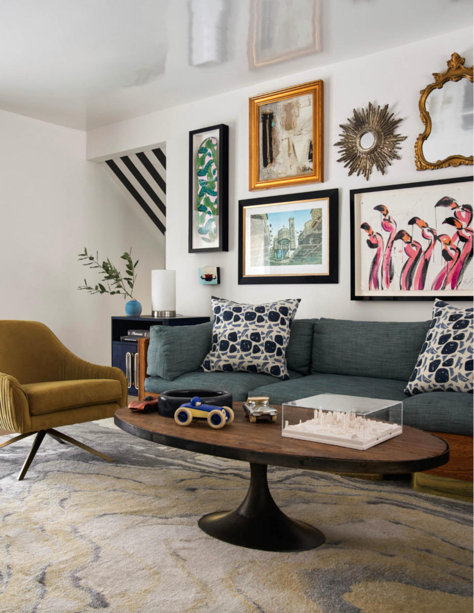 Living room with grey sofa, white walls and gallery wall of artwork and mirrors