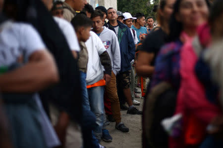 Members of a migrant caravan from Central America line up to receive breakfast at the end of their journey through Mexico, prior to preparations for an asylum request in the U.S., at a shelter in Tijuana, Baja California state, Mexico April 27, 2018. REUTERS/Edgard Garrido