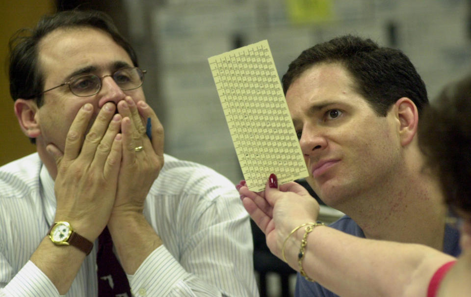 Reporteros miran una de las miles de boletas de votaciones impugnadas en Florida en la elección del 2020. El recuento en ese estado clave fue al final frenado por la Corte Suprema y Goerge W. Bush ganó la presidencia. (AP Photo/Marta Lavandier)