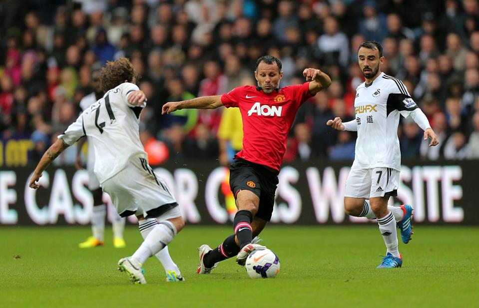 Manchester United's Ryan Giggs (centre) tries to get away from Swansea City's Jose Alberto Canas