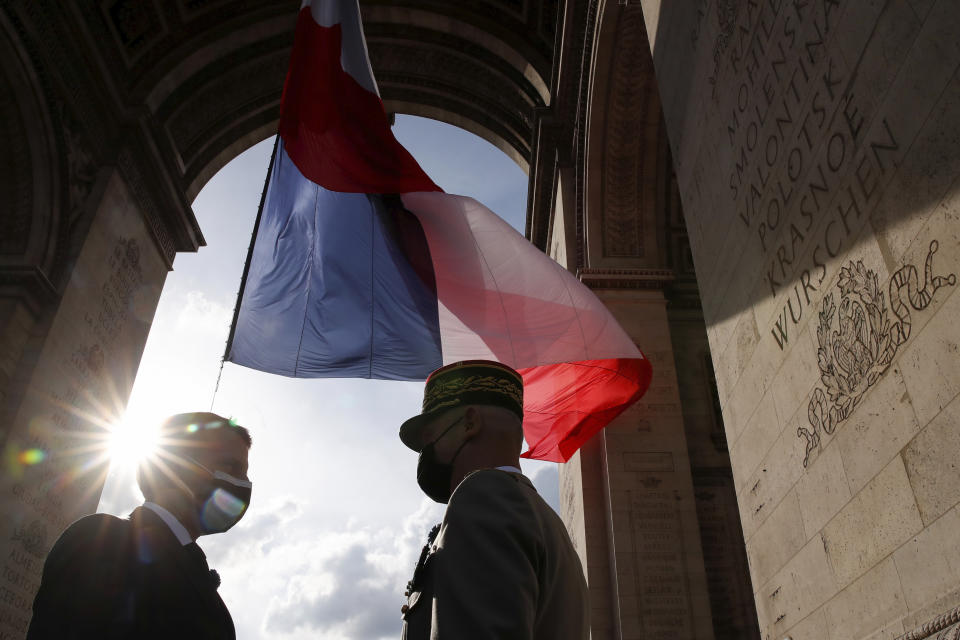 French President Emmanuel Macron, left, talks to Gen. Francois Lecointre during a ceremony at the Arc de Triomphe to mark the 76th anniversary of the end of World War II, in Paris, Saturday, May 8, 2021.(Christian Hartmann/Pool via AP)