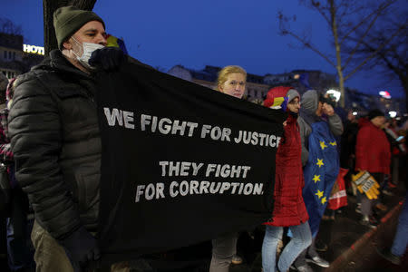 Protesters display a banner that reads "We fight for justice, they fight for corruption" in support of the magistrates that protest against changes made to judicial legislation, in Bucharest, Romania February 22, 2019. Inquam Photos/Octav Ganea via REUTERS