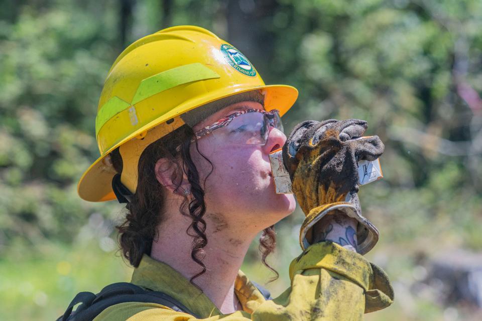 "This protein shake tastes like life," says wildland firefighter Cassandra Brook during a quick break while putting out embers in a burn pile.