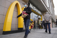 A man carries his take way McDonald's foods as people take order at a machine at a newly opened McDonald's restaurant on Sunday, Dec. 24, 2023. It was tumultuous 2023 for the Chinese economy. Some of the world's biggest brands said they were weighing, or already have decided, to shift manufacturing away from China amid unease about security controls, government protection of their Chinese rivals and Beijing's wobbly relations with Washington. But there was at least one bright spot for Beijing amid all the tough news about declining foreign investment: American fast food companies have announced a surge of investment in a market of 1.4 billion people. KFC, McDonald's and Starbucks are among companies in recent months that have announced plans for major investment in China. (AP Photo/Andy Wong)