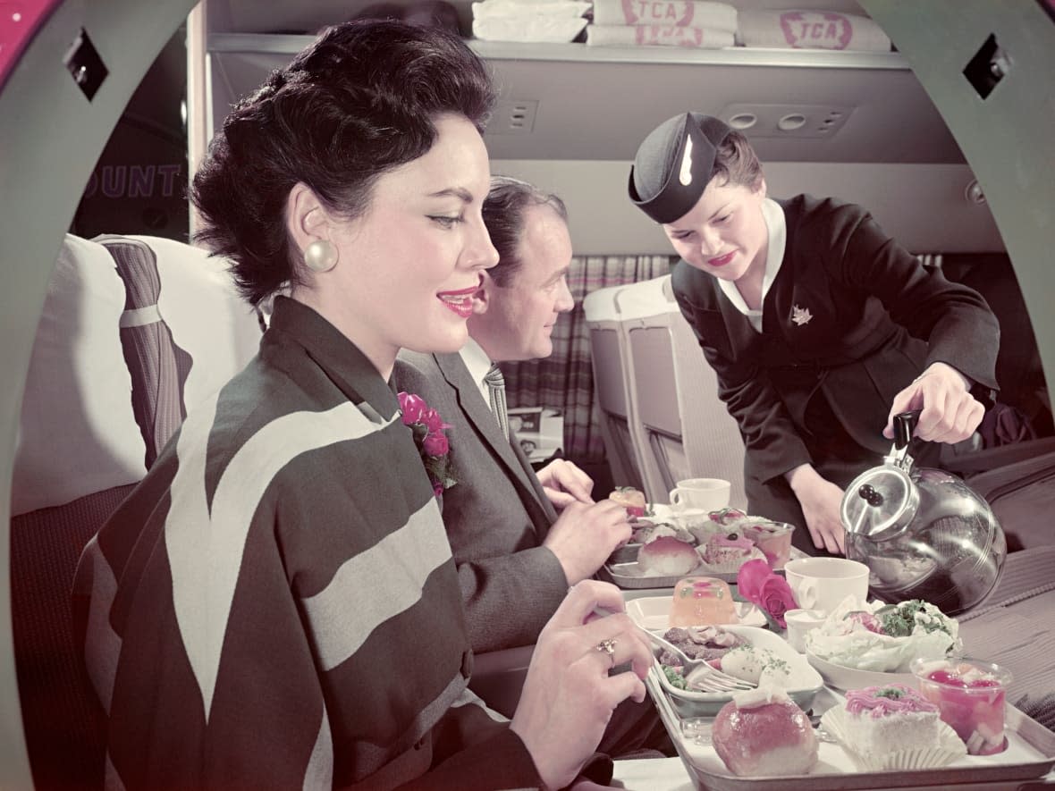 Meal service on a 1955 Trans-Canada Airlines flight. Experts say most people associate the golden age of flying with the era when commercial aviation in Canada was regulated and airlines didn't have to cut costs to stay competitive. (Air Canada - image credit)