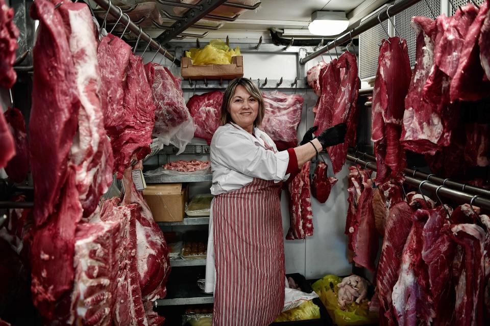 Rania Rapti, a butcher, poses in her family's business in Athens, Greece, on March 5, 2018.