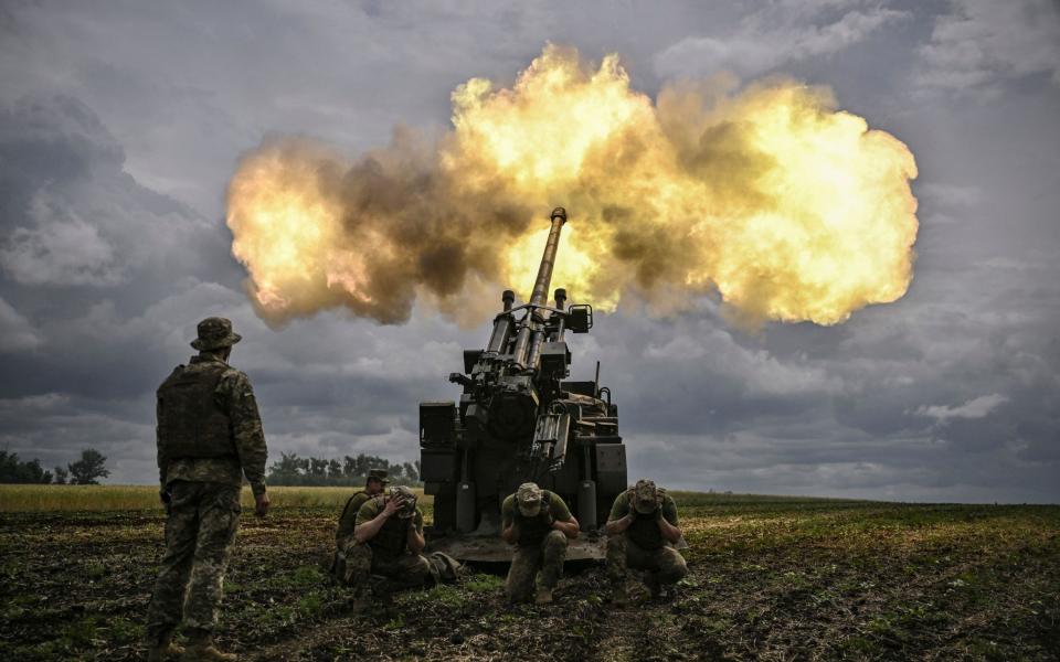 Ukrainian servicemen fire with a French self-propelled 155 mm/52-calibre gun Caesar towards Russian positions at a front line in the eastern Ukrainian region of Donbas on June 15, 2022. - ARIS MESSINIS/AFP