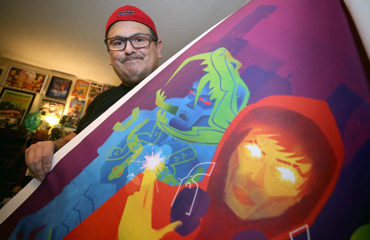 S’Klallam artist Jeffrey Veregge has an exhibit in the Smithsonian National Museum of the American Indian in New York City that will show off some of his work illustrating Marvel superheroes over the next year. He is holding a poster print, used to show the colors for the Smithsonian Museum.