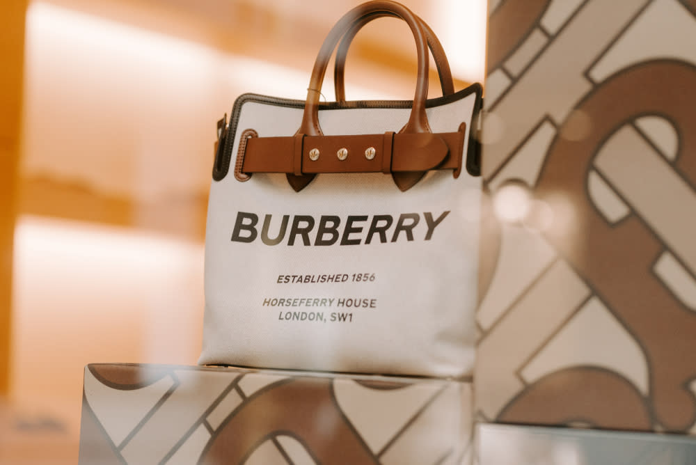 Brown and beige Burberry bag in a store boutique display window showing the logo of the brand