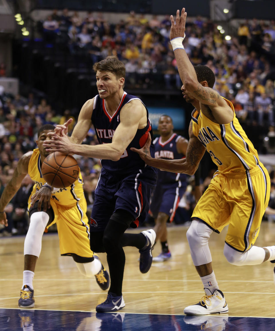 Atlanta Hawks guard Kyle Korver loses control of the basketball defended by Indiana Pacers guard George Hill, right, and Pacers forward Paul George, left, in the first half of an NBA basketball game in Indianapolis, Sunday, April 6, 2014. (AP Photo/R Brent Smith)