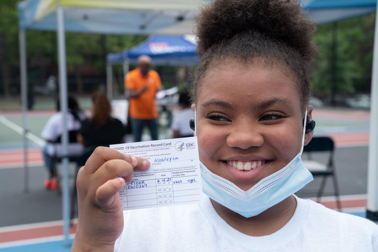 Kabreyia Lee Torres, 12, shows off her Covid-19 vaccination card at one of New York City's school vaccination sites outside Bronx Writing Academy in the Bronx, New York.