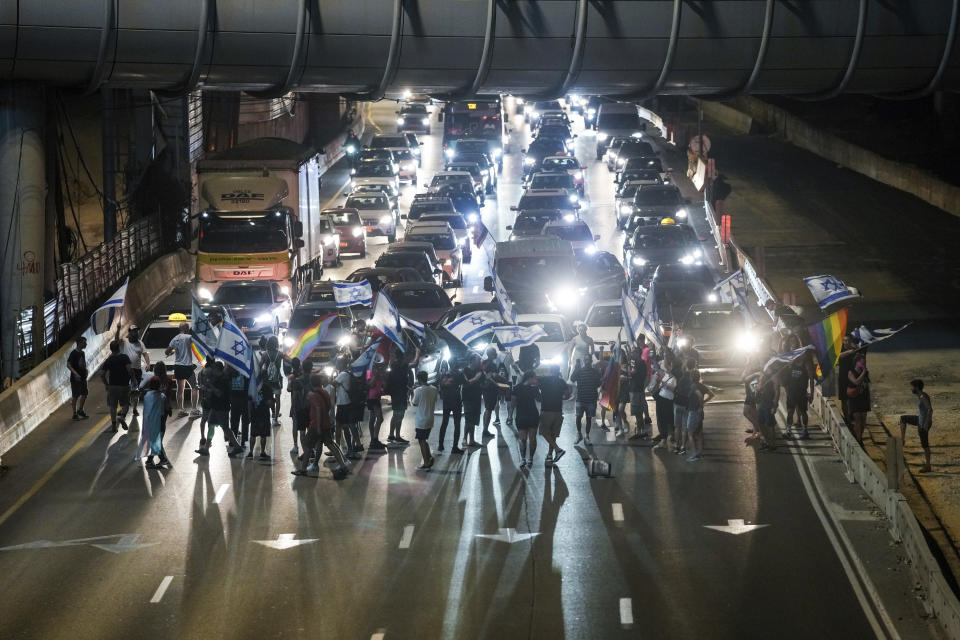 Demonstrators block a highway during a protest against plans by Prime Minister Benjamin Netanyahu's government to overhaul the judicial system, in Tel Aviv, Israel, Saturday, July 22, 2023. (AP Photo/Mahmoud Illean)