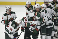 Minnesota Wild players congratulate Marcus Johansson, front center, on his overtime goal in an NHL hockey game against the Los Angeles Kings in Los Angeles, Saturday, Jan. 16, 2021. (AP Photo/Kelvin Kuo)