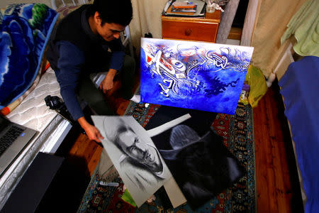 Roohullah Mosawi, a refugee from Afghanistan, displays the drawings he has completed for his art studies in his bedroom in a house he rents with other refugees, in the western Sydney suburb of Guildford, Australia, July 17, 2016. REUTERS/David Gray