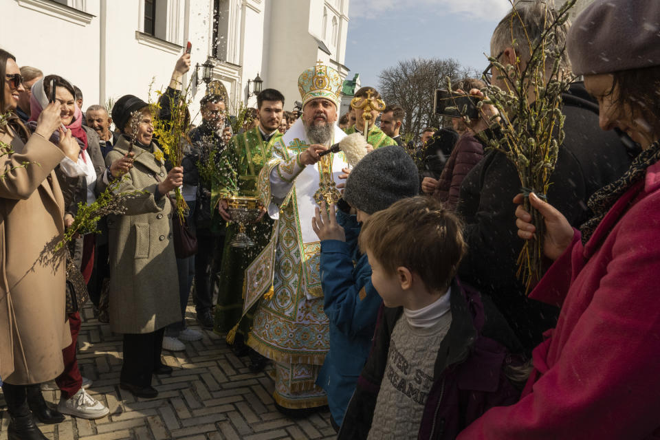 Metropolitan Epiphanius, head of the Orthodox Church of Ukraine blesses worshipers as they gather to celebrate Palm Sunday at Kiev-Pechersk Lavra monastery, Ukraine's most revered Orthodox site in Kyiv, Ukraine, Sunday, April 9, 2023. (AP Photo/Adam Pemble)