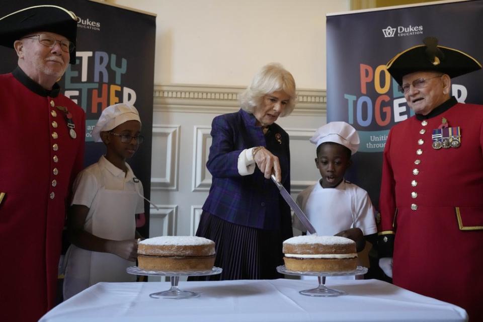 Camilla cuts a Victoria sponge cake for which she had shared her personal recipe for Poetry Together tea parties (Frank Augstein/PA) (PA Wire)