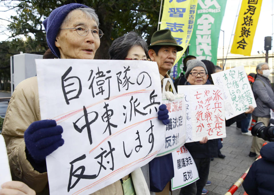 People hold placards protesting against a troop dispatch to Middle East outside the prime minister's official residence in Tokyo Friday, Dec. 27, 2019. Japan on Friday approved a contentious plan to send its naval troops to the Middle East to contribute to the peace and stability in the area and ensure the safety of Japanese ships transporting oil, a mission crucial to an energy-poor country that heavily depends on oil imports from the region. The placard at left reads: "Oppose a dispatch of Japan Self-Defense Forces to Middle East." (Hiroki Yamauchi/Kyodo News via AP)