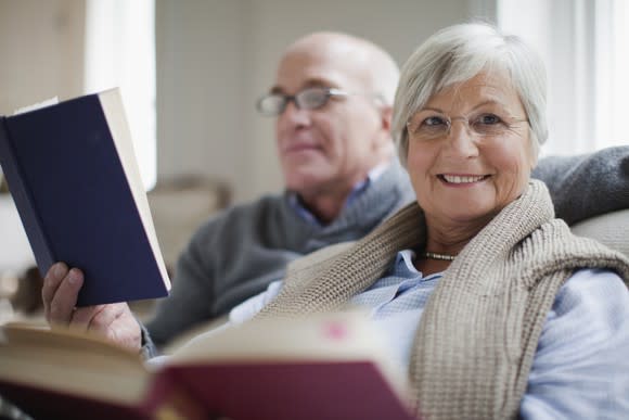 Senior man and woman reading books and smiling