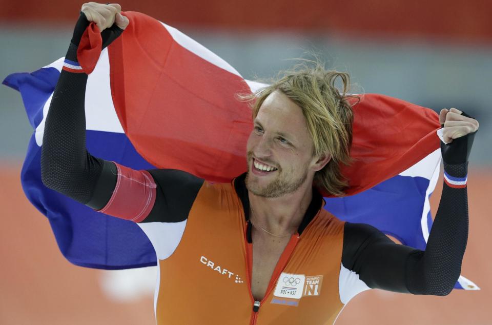 Michel Mulder from the Netherlands holds his national flag and celebrates winning gold in the men's 500-meter speedskating race at the Adler Arena Skating Center during the 2014 Winter Olympics, Monday, Feb. 10, 2014, in Sochi, Russia. (AP Photo/Matt Dunham)