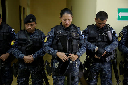 Police officers react during a homage for three colleagues, who were killed during an attack, during a homage at the headquarters of the Civil National Police (PNC) in Guatemala City, Guatemala, March 21, 2017. REUTERS/Luis Echeverria