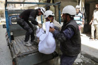 This photo provided by the anti-government activist group Aleppo Media Center (AMC), which has been authenticated based on its contents and other AP reporting, shows civil defense rescue workers carrying the body of a man who was killed by a government forces airstrike, in Aleppo, Syria, Monday, April 28, 2014. Dozens of people were killed and wounded in fighting between pro-Assad forces and rebels in the northern city of Aleppo on Sunday, reported the Britain-based Syrian Observatory for Human Rights. The fight for Aleppo is particularly important now, with analysts saying they expect Assad's forces will try wrest as much of the city as possible before elections. (AP Photo/Aleppo Media Center AMC)