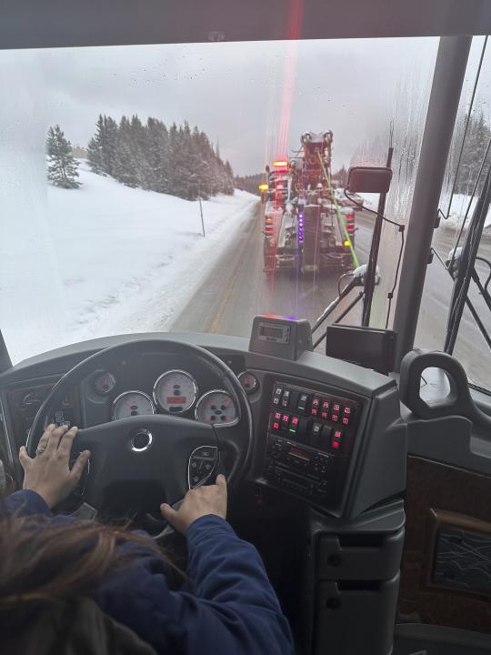 In this photo provided by Brenda Djorup, a Thera-ski bus gets towed over Vail Pass, Colo., Wednesday, March 13, 2024, after the transmission overheated. A weekly ski trip for about 50 women from the Denver area turned into an overnight ordeal when their bus got stuck in a snowstorm behind jackknifed semi tractor-trailers on their way back from Vail. (Brenda Djorup via AP))