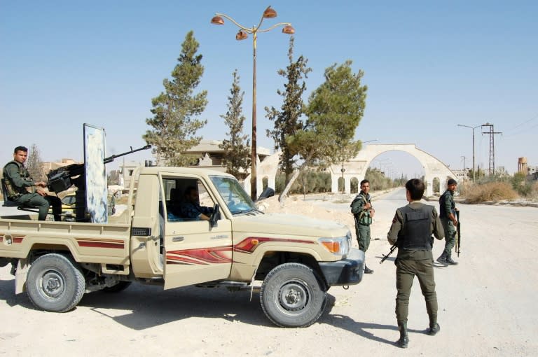 Syrian soldiers and pro-regime fighters gather in Al-Qaryatain on October 22, 2017, a day after retaking the desert town from the Islamic State group