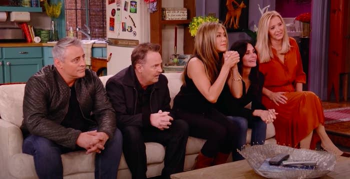 The cast of Friends sitting on the show's famous couch during the reunion show