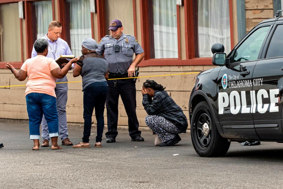 Family members react Monday, Oct. 10, 2022, at the scene as Oklahoma City police investigate a fatal shooting at the Plaza Inn in Oklahoma City.