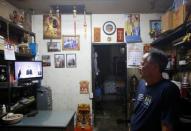 A shopkeeper watches an address by Thailand's Prime Minister Prayuth Chan-ocha on the passing of King Bhumibol Adulyadej in Bangkok, Thailand October 14, 2016. REUTERS/Edgar Su