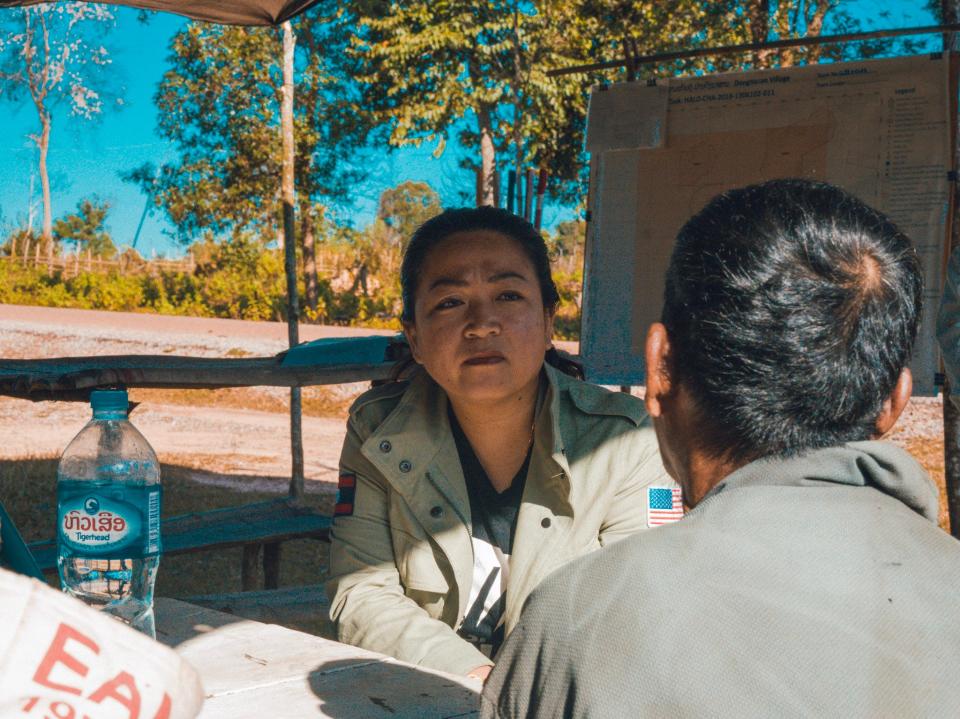 Sera Koulabdara, chair of the U.S. Campaign to Ban Landmines and Cluster Munition Coalition, interviews cluster bomb survivor Yong Kham in southern Laos in November 2022.
