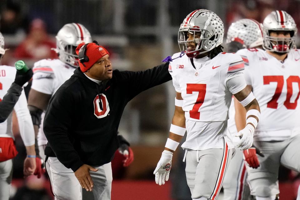 Ohio State cornerback Jordan Hancock gets a pat on the back from coach Perry Eliano during the Buckeyes' 24-10 win over Wisconsin.