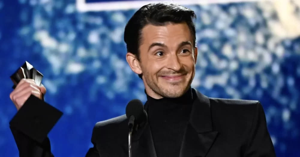 Actor Jonathan Bailey accepting a Critics Choice Award on stage.