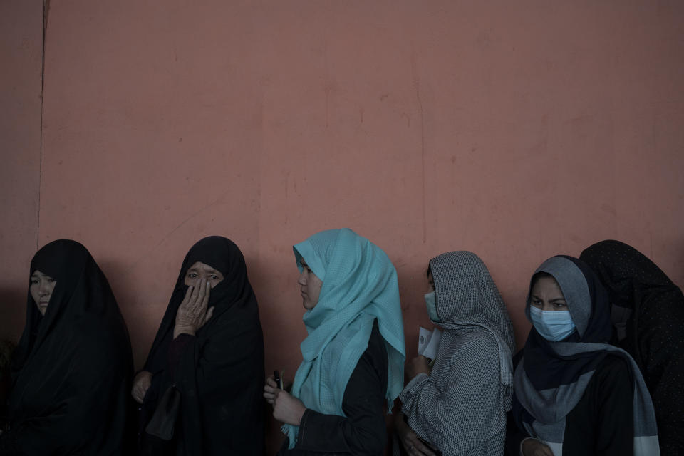 Women wait in a line to receive cash at a money distribution organized by the World Food Program (WFP) in Kabul, Afghanistan, Wednesday, Nov. 3, 2021. Afghanistan's economy is fast approaching the brink and is faced with harrowing predictions of growing poverty and hunger. (AP Photo/Bram Janssen)