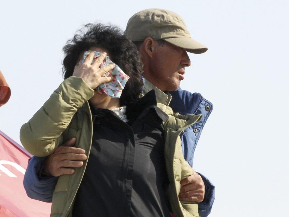 A relative of a passenger aboard the sunken ferry Sewol cries while waiting for her missing loved one at a port in Jindo, South Korea, Monday, April 21, 2014. Divers continued the grim work of recovering bodies from inside the sunken South Korean ferry in the water off the southern coast Monday, as a newly released transcript showed the ship was crippled by confusion and indecision well after it began listing. The transcript suggests that the chaos may have added to a death toll that could eventually exceed 300. (AP Photo/Ahn Young-joon)