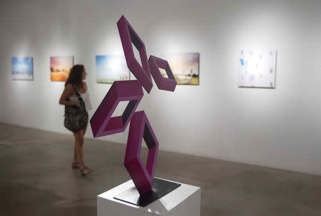 A woman looks at artwork at Gallery 212 during this month's Art Walk in the Miami neighborhood of Wynwood October 11, 2014. REUTERS/Andrew Innerarity
