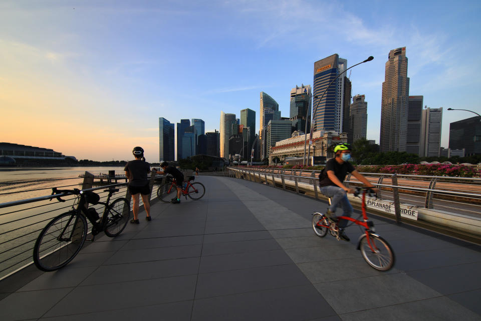 People cycle along the Jubilee Bridge with the city skyline pictured in the background at Marina Bay on February 15, 2021 in Singapore.  (Photo by Suhaimi Abdullah/NurPhoto via Getty Images)